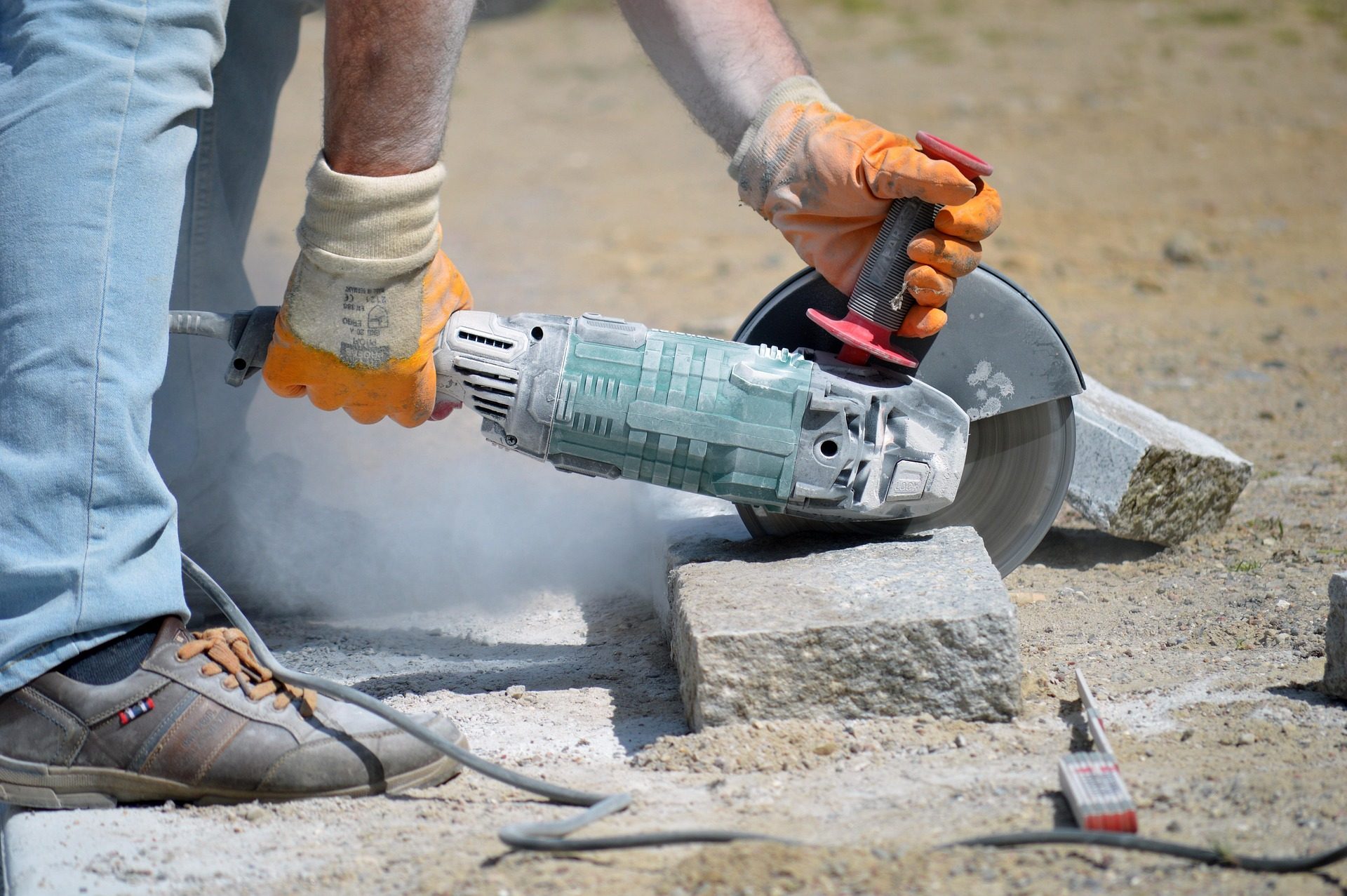 Handwerker schneidet einen Granitstein mit dem Trennschleifer